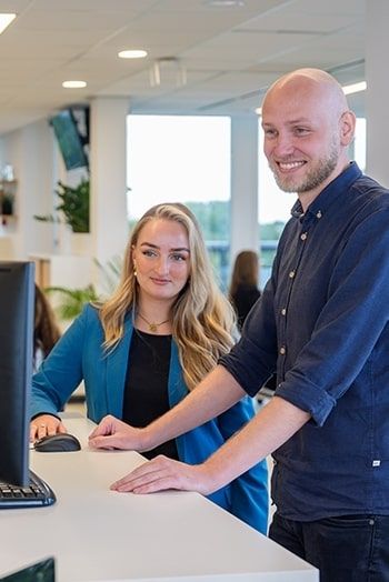 Twee collega’s overleggen over implementatie van PIM-software